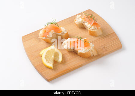 Salmone affumicato tartine sul tagliere di legno Foto Stock