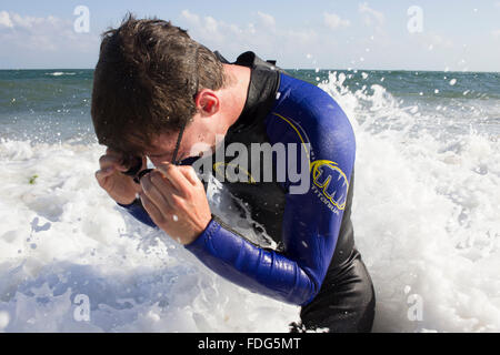 Un nuotatore catturati nel surf a Gyllyngvase Beach, Falmouth, Cornwall Foto Stock