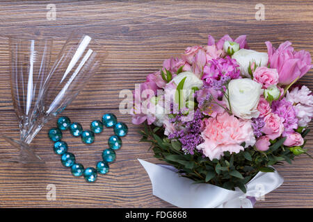 Fiori di San Valentino con gioielli heartshaped sfondo di legno Foto Stock