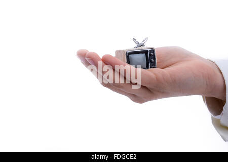 Bambino in possesso di un televisore n la sua mano su uno sfondo bianco Foto Stock