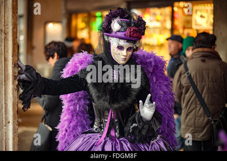 Donna vestita di viola vestiti veneziano pongono al 2016 Carnevale a Venezia Italia Foto Stock