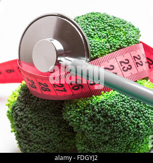 La dieta mangiare sano controllo del peso del concetto. Closeup broccoli verde rosso con nastro di misurazione e lo stetoscopio Foto Stock