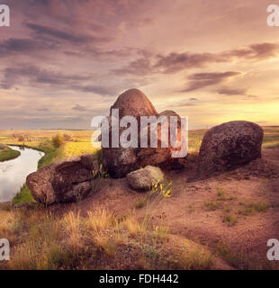 Bella estate tramonto sul fiume con Orange Sky, nuvole, rocce Foto Stock
