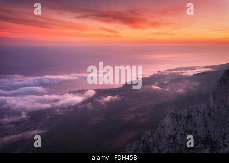 Bellissimo paesaggio con mare, colorato tramonto e nuvole basse. Sullo sfondo della natura Foto Stock