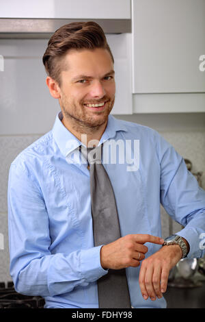 Uomo bello arrivare pronto per lavoro e mostra che egli ha poco tempo Foto Stock