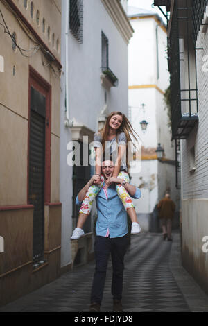 L uomo dando la sua ragazza un piggyback, Siviglia, Spagna Foto Stock