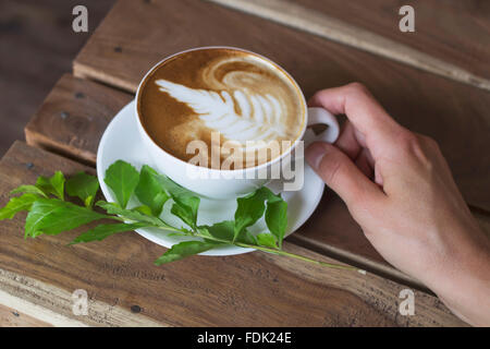 Una donna azienda tazza di cappuccino Foto Stock