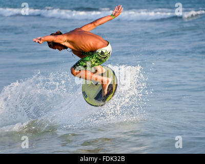 Un skimboarder esegue un trucco sulla spiaggia di Santa Maria, Isola di Sal, Isole di Capo Verde. Foto Stock