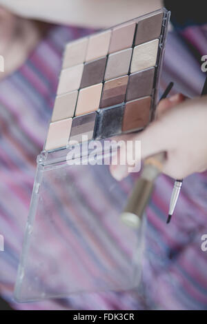 Mano azienda ombretto pallet e make-up pennelli Foto Stock