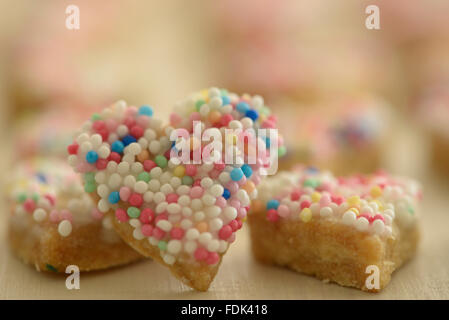 Biscotti a forma di cuore coperti da spruzzi multicolore Foto Stock