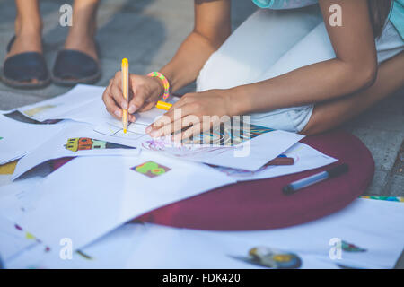 Ragazza inginocchiati su disegno di massa Foto Stock