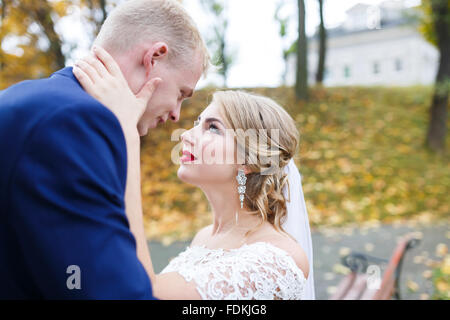 Sposa sposo abbraccia contro lo sfondo di foglie di autunno Foto Stock