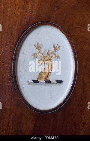 Vista ravvicinata della Tredegar crest sul retro di una sedia in mogano nel lato Hall a Tredegar House, Newport, nel Galles del Sud. La sedia è uno di una serie di fine del XVIII secolo che sono originali per la casa. Foto Stock