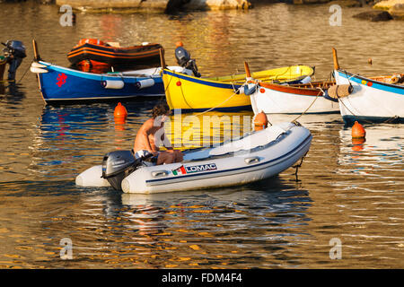 Un pescatore sulla sua barca tornando al porto di Vernazza, Cinque Terre National Park, Liguria, Italia. Foto Stock