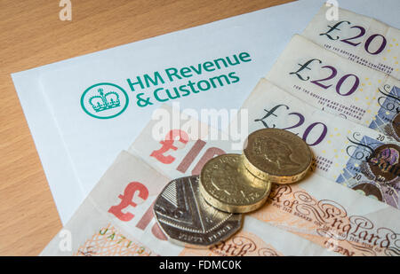 Una carta intestata HMRC con denaro - le banconote e le monete metalliche. Foto Stock