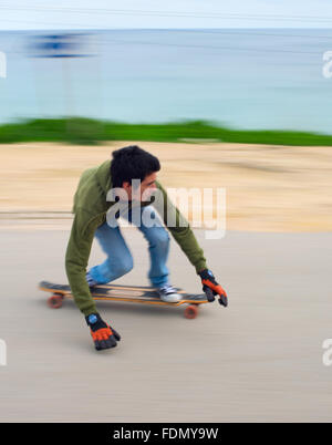 Moto Blured di adolescenti in un longboard andando giù per la collina. Foto Stock