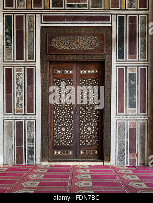 Vecchio marmo decorato a parete con una storica ornato porta in legno Foto Stock