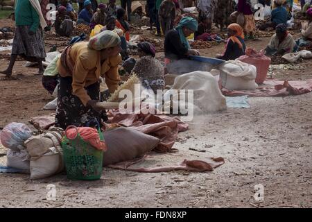 Una signora setaccia la granella in un mercato in Dorze, Etiopia Foto Stock