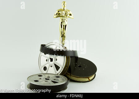 Premio Oscar Oscar statua con vintage di bobine di film su bianco. Foto Stock