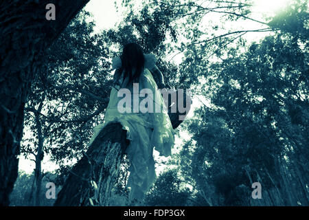 Misteriosa donna in abito bianco nella foresta Foto Stock