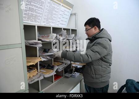 Beijicun, la Cina della Provincia di Heilongjiang. 30 gen, 2016. Portalettere Wang Xiulong ordina lettere presso l'ufficio postale di Beijicun, o "polo nord villaggio", nel nord-est della Cina di Provincia di Heilongjiang, Gennaio 30, 2016. Beijicun, una piccola città della Cina settentrionale della contea di Mohe, è uno dei luoghi più freddi nel paese. La temperatura più bassa mai registrata qui era meno 52,3 gradi Celsius. Wang è la suola portalettere di Beijicun Post Office che lavora qui da dieci anni fa. © Wang Kai/Xinhua/Alamy Live News Foto Stock