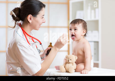 Medico dando medicamento con un cucchiaio Foto Stock