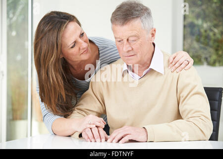 Confuso Senior l'uomo con la figlia adulta a casa Foto Stock