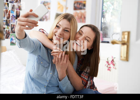 Due ragazze adolescenti tenendo Selfie In camera da letto a casa Foto Stock