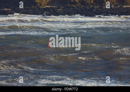 Gli appassionati di windsurf in tempesta surf a Bigbury-on-Sea, Devon, Gran Bretagna. Foto Stock