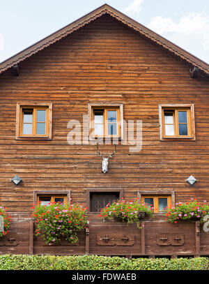 Vecchia casa in legno con un cranio e le corna di cervo sulla parete per esterno Foto Stock