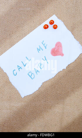 Call me scritto su un foglio di carta fissato mediante le puntine per il legno bulletin board Foto Stock