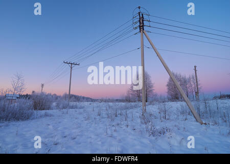 La linea di alimentazione in campagna con bella crimson sky in background Foto Stock