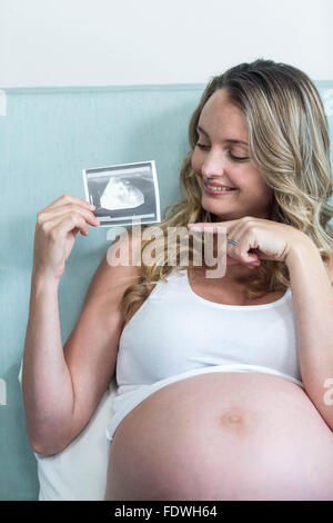 Donna incinta che mostra una immagine ad ultrasuoni Foto Stock