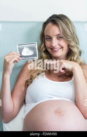 Donna incinta che mostra una immagine ad ultrasuoni Foto Stock