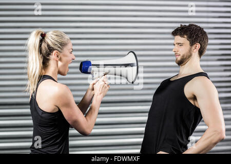 Trainer urla attraverso il megafono Foto Stock