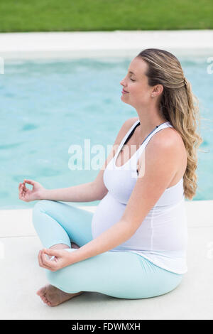 Donna incinta fare yoga Foto Stock