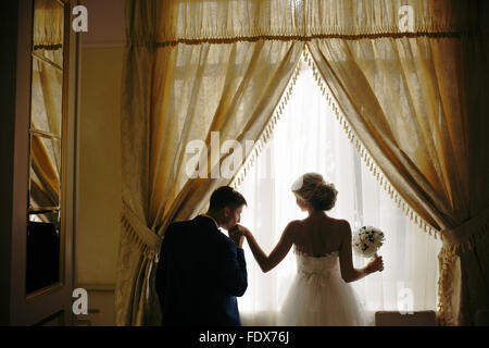 Sposa e lo sposo in piedi nella parte anteriore della finestra Foto Stock