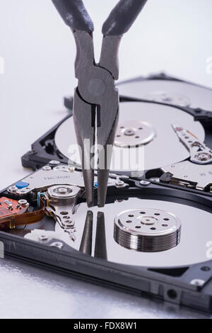 Coppia di pinze per il fai da te in bilico su piatto di un spogliato unità disco rigido - metafora visiva per il concetto di strumenti software, strumenti IT. Foto Stock