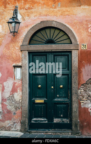 La porta e splendidamente indossato un muro di una casa nel quartiere di Trastevere a Roma, Italia Foto Stock