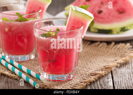 Anguria drink in bicchieri con fette di cocomero Foto Stock