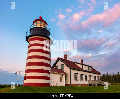 Lubec, Maine: West Quoddy Head Light all'alba con nuvole rosa e calare della luna. Foto Stock