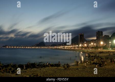 Rio de Janeiro, Brasile, 2° febbraio 2016. Lucertole da mare godono di Leme spiaggia al tramonto, dopo una calda giornata estiva. Una lunga esposizione catturato il cloud e il movimento del mare. Foto Stock