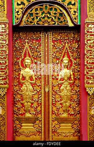 Sculture in legno su una porta del tempio di Wat Fon Soi, Chiang Mai, Thailandia Foto Stock