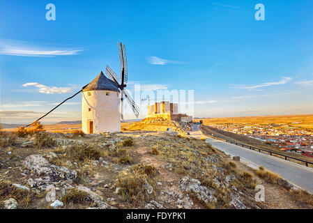 Il mulino a vento e il castello in background. A Consuegra. Don Chisciotte rotta. Toledo. Castilla la Mancha. Spagna Foto Stock