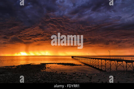 Distanti tempesta di pioggia su orizzonte in oceano aperto come si vede dal vecchio e storico pontile in legno in Ceduna, Sud Australia Foto Stock