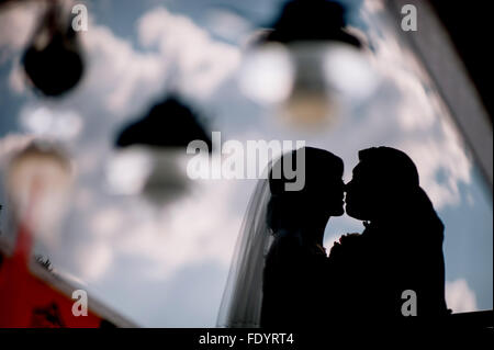 Sposa e lo sposo baciare silhouette sul loro matrimonio Foto Stock