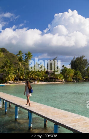 Donna che cammina sul molo, Hauru Point, Mo'Orea, Isole della Società, Polinesia Francese Foto Stock