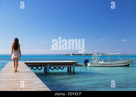 Donna che cammina sul molo, Hauru Point, Mo'Orea, Isole della Società, Polinesia Francese Foto Stock