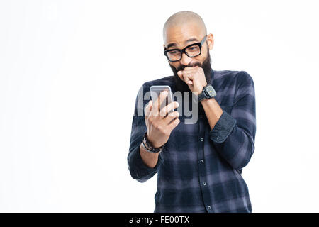 Allegro barbuto giovane americano africano uomo calvo con la barba in bicchieri utilizza lo smartphone e ridere Foto Stock