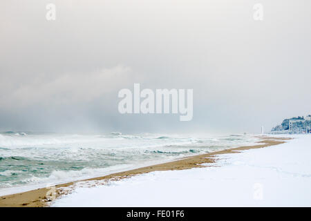 La neve sulla spiaggia su una ventosa giornata invernale e. Foto Stock